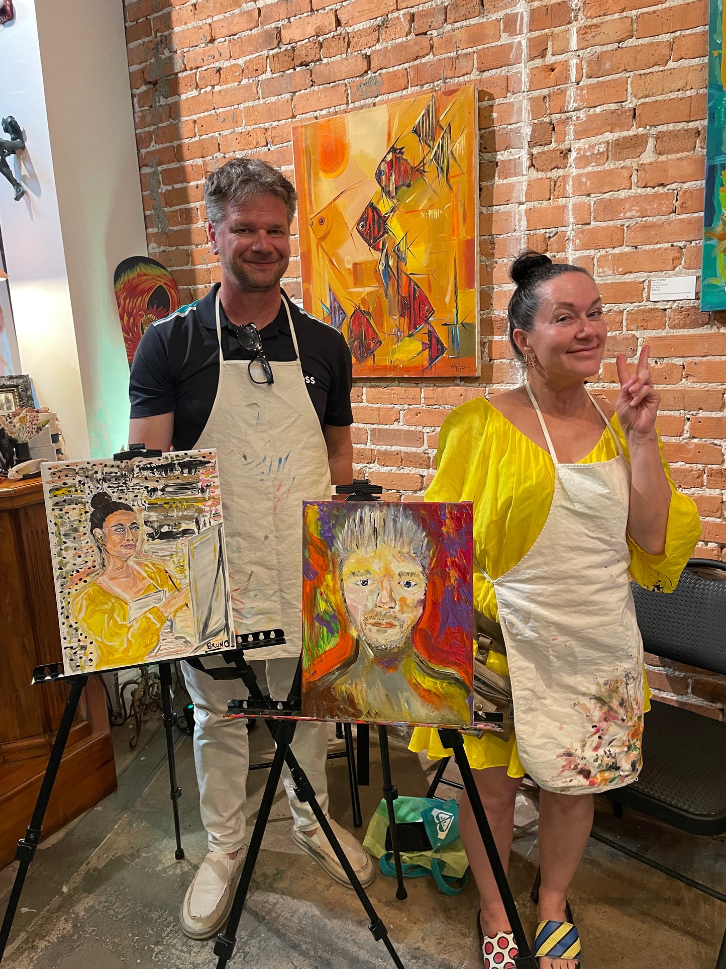 Couples proudly holding up the portrait artwork they painted of each other at the Marcolina's paint each other sip and paint event.