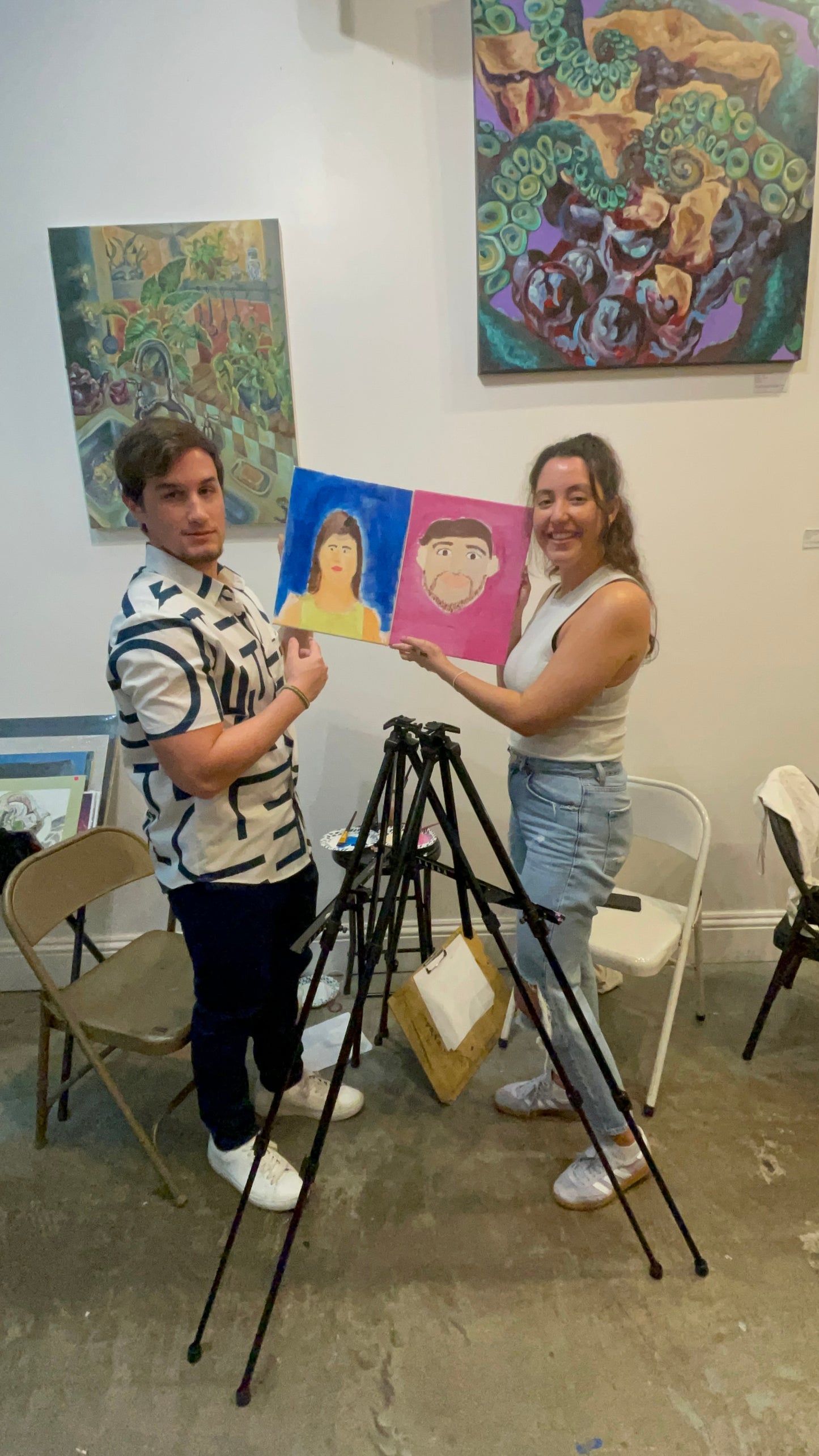 Couples proudly holding up the portrait artwork they painted of each other at the Marcolina's art gallery paint each other sip and paint event.