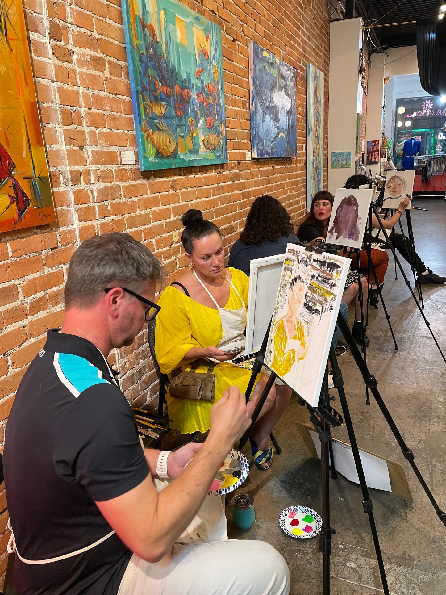 Group of guests painting together during a lively sip and paint session at Martcolina's gallery in Ybor City, Tampa.