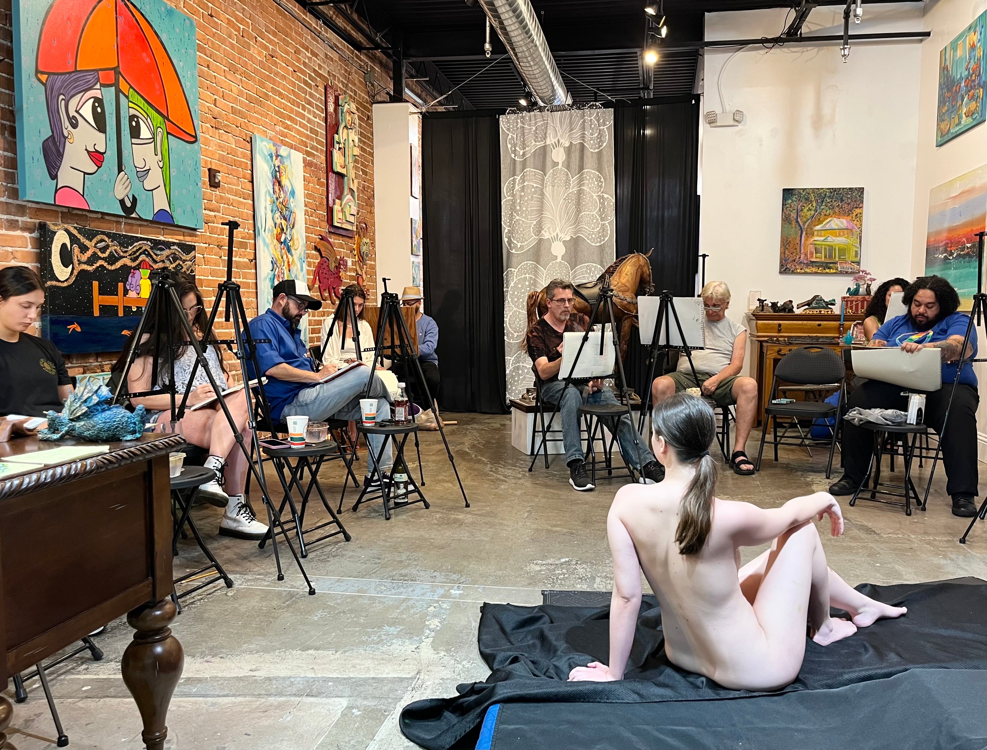 Figure drawing session with a female model where artists and guests are drawing the model at Marcolina's art gallery.